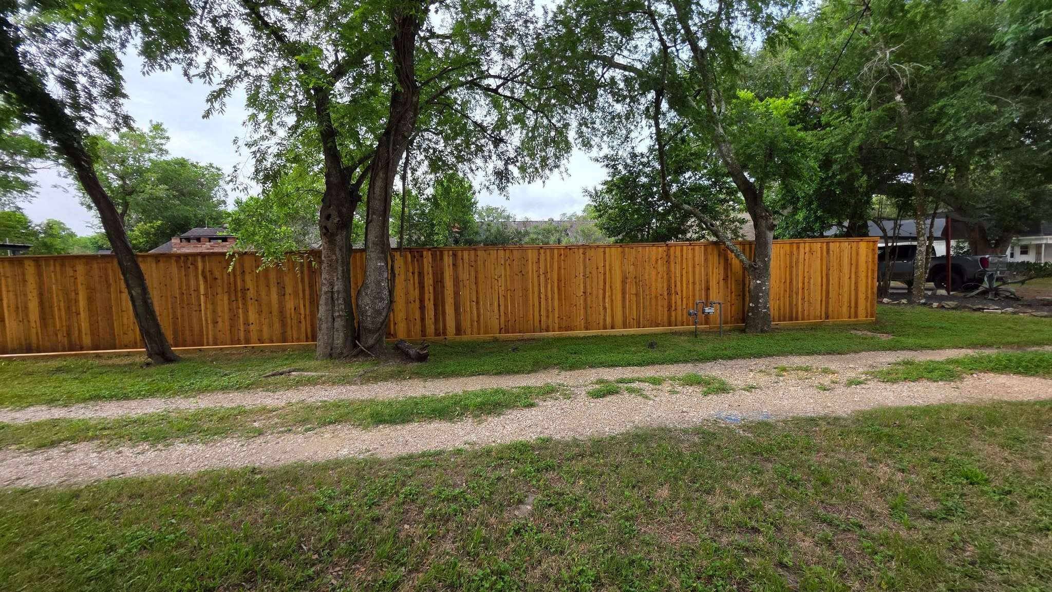 Long freshly stained cedar fence surrounding a large Houston-area property